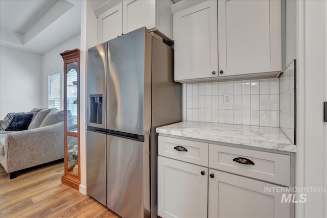1275 Terra Ave, Twin Falls, ID 83301 - kitchen with stainless steel fridge, tasteful backsplash, light wood-style flooring, open floor plan, and light stone countertops