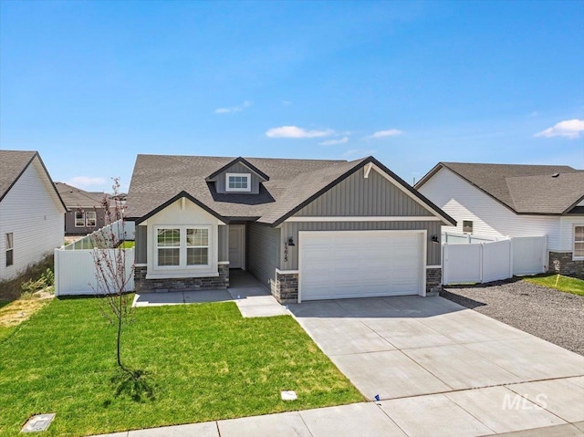 1275 Terra Ave, Twin Falls, ID 83301 - view of front facade featuring an attached garage, stone siding, driveway, roof with shingles, and board and batten siding