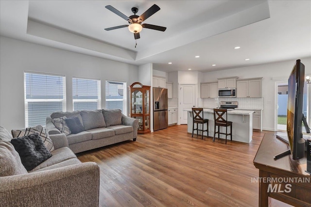 1275 Terra Ave, Twin Falls, ID 83301 - living room with a tray ceiling, ceiling fan, wood finished floors, and recessed lighting