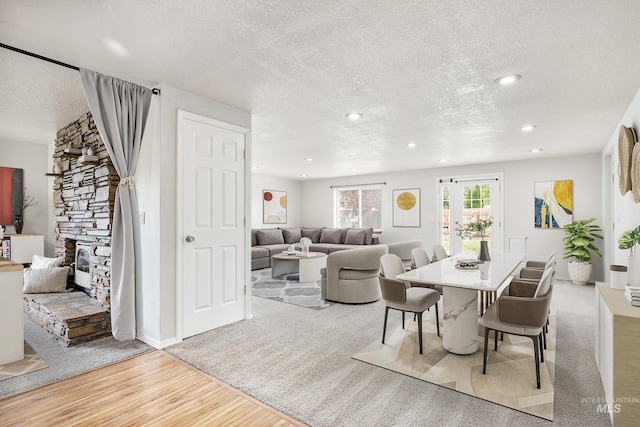 5457 S Oseola Pl, Boise, ID 83709 - dining room featuring a textured ceiling, wood finished floors, a stone fireplace, and recessed lighting