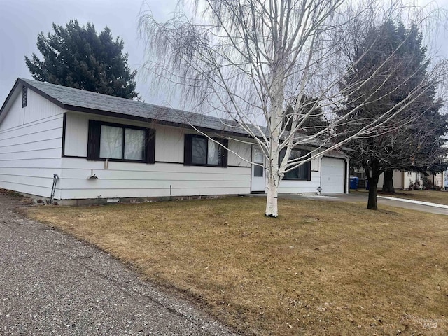 ranch-style home with a front yard, roof with shingles, driveway, and an attached garage