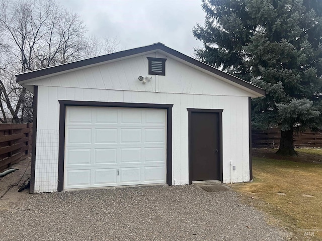 detached garage featuring fence