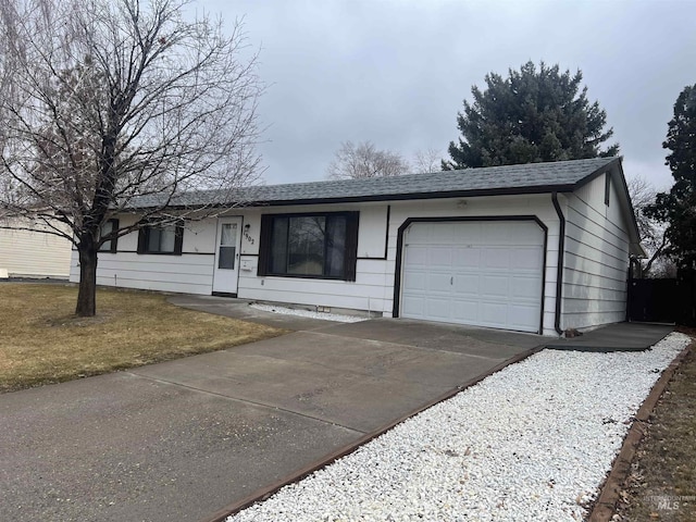 ranch-style home with an attached garage, driveway, a shingled roof, and a front yard