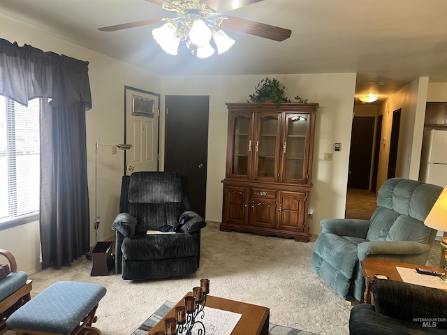 living area featuring a ceiling fan and light colored carpet