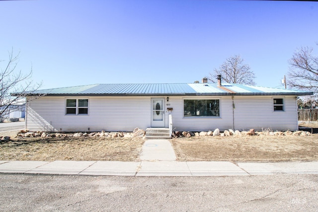 single story home featuring metal roof