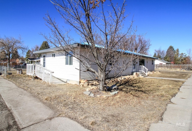 view of side of property featuring entry steps and fence