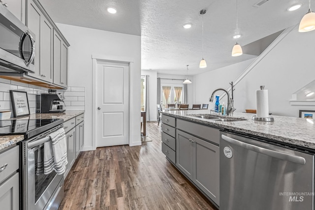 3084 N Network Ln, Boise, ID 83704 - kitchen with appliances with stainless steel finishes, gray cabinets, dark wood finished floors, light stone countertops, and backsplash