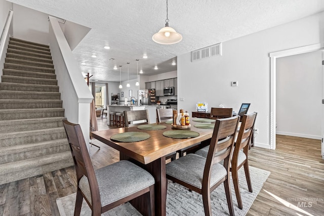 3084 N Network Ln, Boise, ID 83704 - dining space featuring stairs, a textured ceiling, light wood-type flooring, and recessed lighting