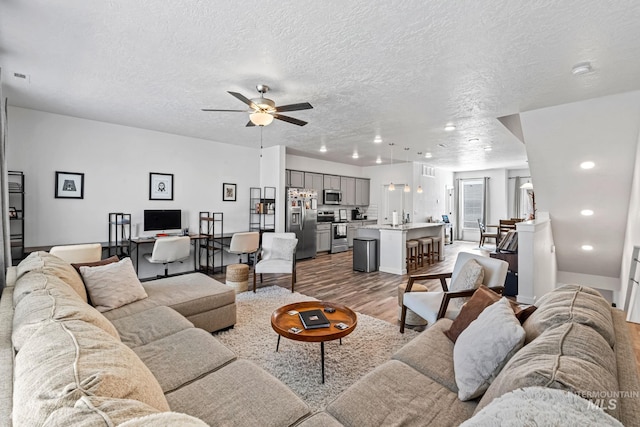 3084 N Network Ln, Boise, ID 83704 - living room featuring light wood-type flooring, a textured ceiling, a ceiling fan, and recessed lighting