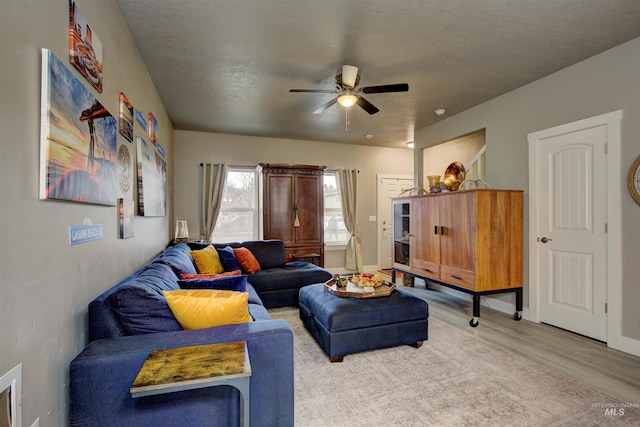 living room featuring ceiling fan and light wood-type flooring