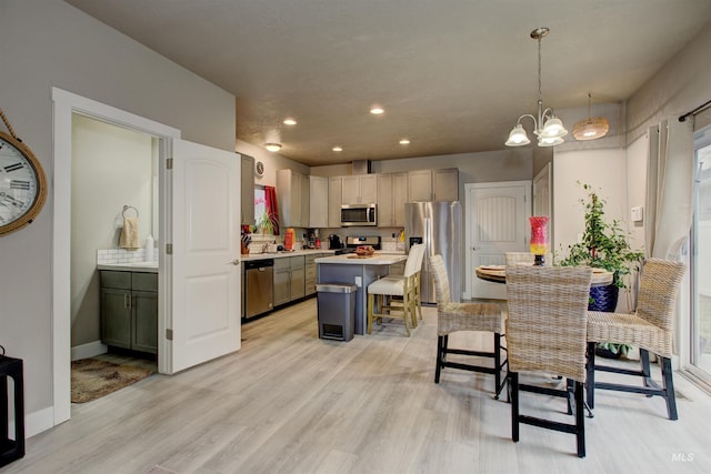 dining area with a notable chandelier, light hardwood / wood-style floors, and sink