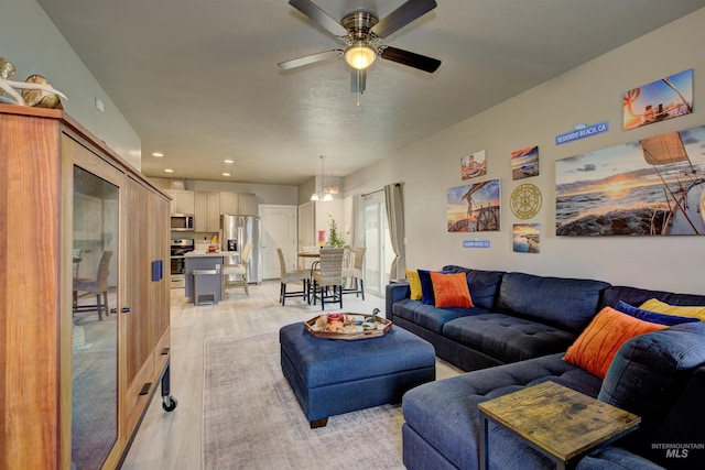 living room with ceiling fan and light hardwood / wood-style flooring