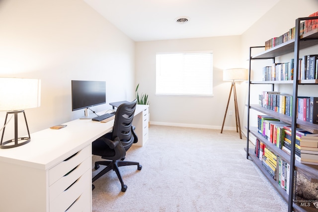 office with baseboards, visible vents, and light colored carpet