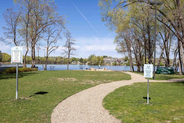 view of home's community featuring a lawn and a water view