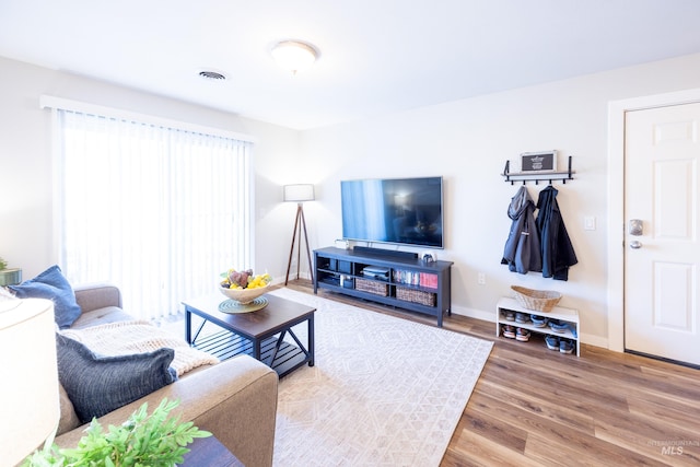 living room featuring baseboards, wood finished floors, and visible vents