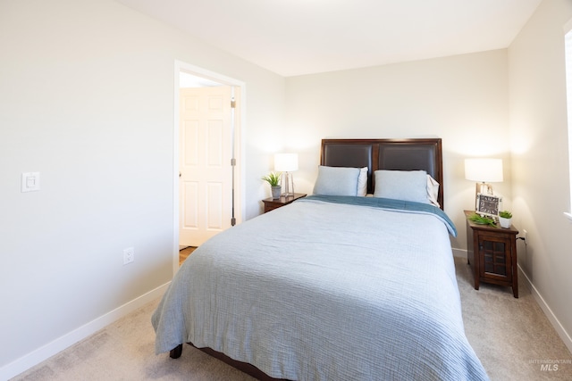 bedroom with baseboards and light colored carpet