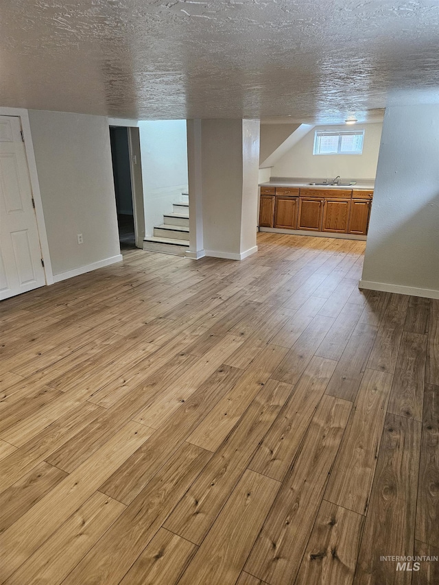 407 E Freeport St, Caldwell, ID 83605 - below grade area featuring stairway, light wood-type flooring, and a textured ceiling