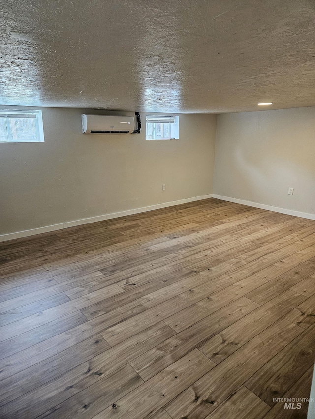 407 E Freeport St, Caldwell, ID 83605 - below grade area with a wall mounted air conditioner, a textured ceiling, hardwood / wood-style flooring, and healthy amount of natural light
