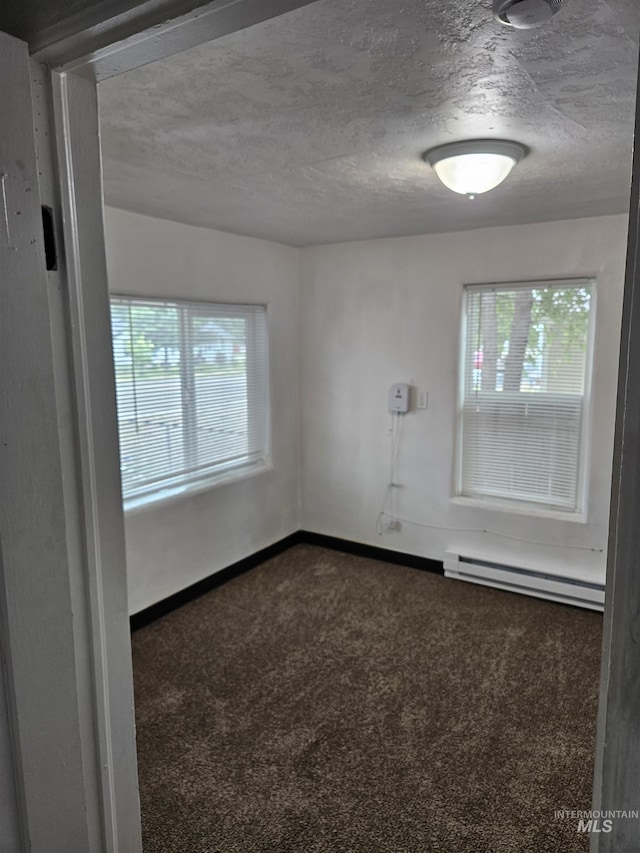 407 E Freeport St, Caldwell, ID 83605 - empty room featuring a baseboard heating unit, carpet flooring, and a textured ceiling