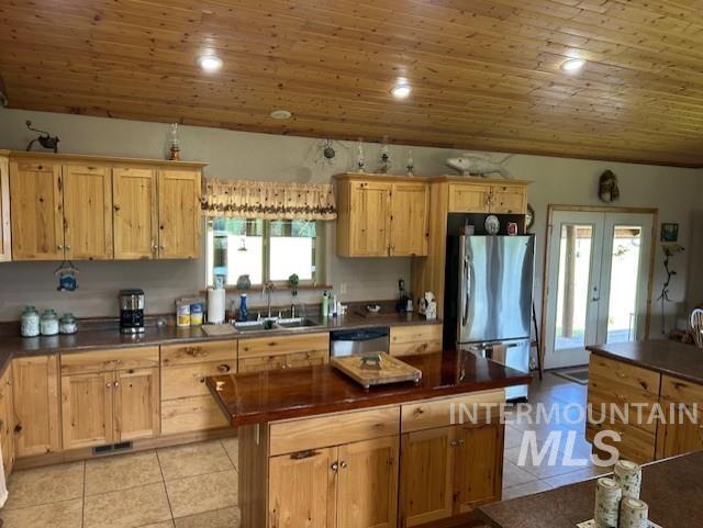 1621 Doumecq Rd, Cottonwood, ID 83522 - kitchen featuring appliances with stainless steel finishes, dark countertops, light tile patterned flooring, a sink, and lofted ceiling