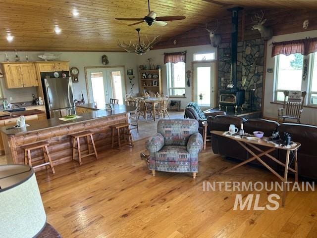1621 Doumecq Rd, Cottonwood, ID 83522 - living area featuring light wood-style flooring, a wood stove, wooden ceiling, ceiling fan, and vaulted ceiling