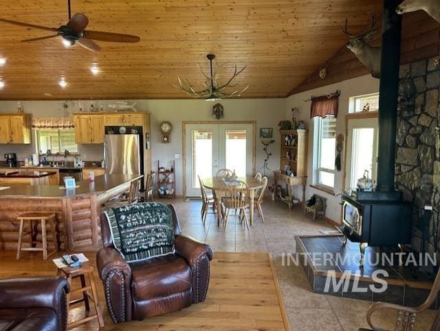 1621 Doumecq Rd, Cottonwood, ID 83522 - living area featuring a wood stove, french doors, a ceiling fan, wood ceiling, and light tile patterned floors