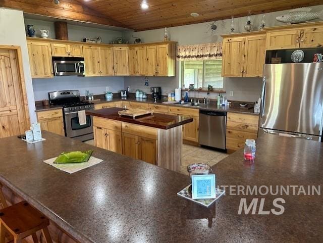 1621 Doumecq Rd, Cottonwood, ID 83522 - kitchen featuring appliances with stainless steel finishes, a kitchen island, light brown cabinetry, vaulted ceiling, and wood ceiling