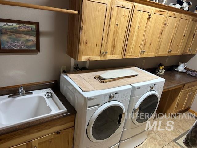 1621 Doumecq Rd, Cottonwood, ID 83522 - laundry room with washing machine and dryer, cabinet space, and tile patterned flooring