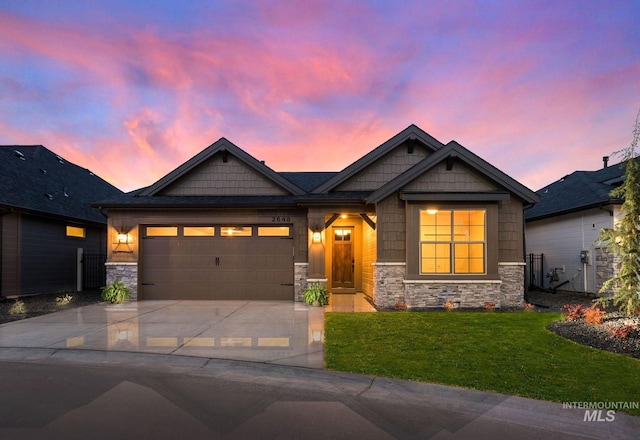 craftsman-style home with an attached garage, a yard, concrete driveway, and stone siding