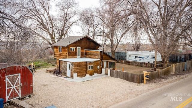 exterior space featuring a storage unit, an outbuilding, and fence