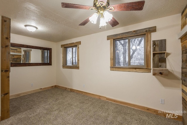 carpeted empty room with baseboards, a textured ceiling, and ceiling fan