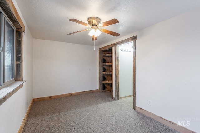 unfurnished bedroom featuring baseboards, a textured ceiling, and carpet