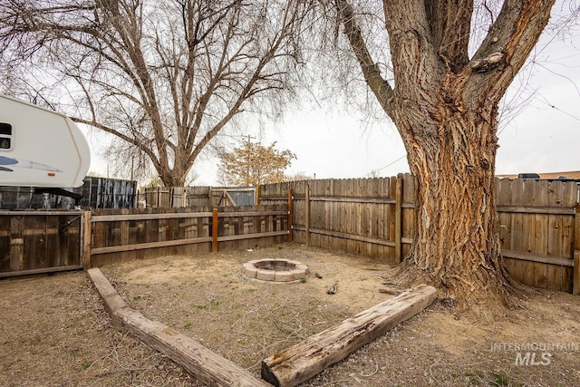 view of yard featuring a fire pit and a fenced backyard