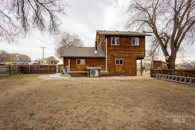 rear view of house featuring ac unit and fence