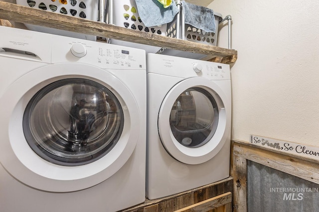 laundry area with laundry area, independent washer and dryer, and a textured wall