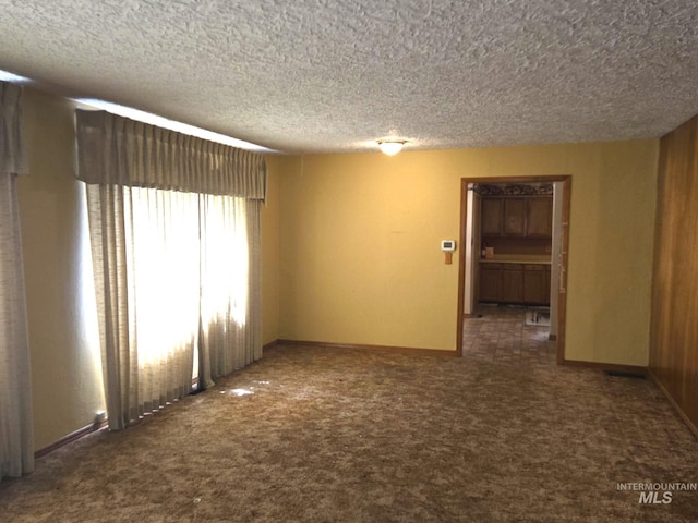 495 1st St E, Huntington, OR 97907 - empty room featuring a textured ceiling, carpet flooring, and baseboards