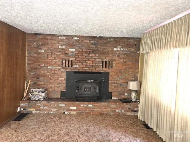 495 1st St E, Huntington, OR 97907 - unfurnished living room with carpet floors, a wood stove, wood walls, and a textured ceiling
