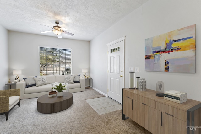 living room with a ceiling fan, light carpet, and a textured ceiling