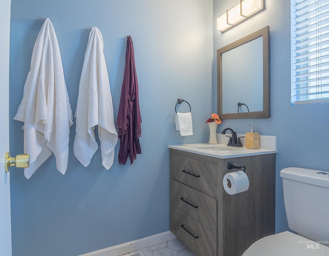 half bathroom featuring vanity and toilet