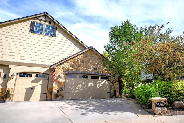 view of side of property with stone siding and driveway