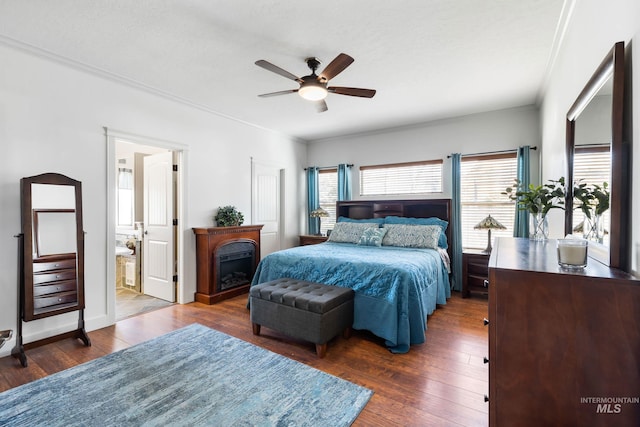 bedroom with a fireplace, a ceiling fan, hardwood / wood-style floors, and ornamental molding