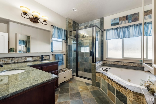 bathroom featuring tasteful backsplash, two vanities, a sink, a shower stall, and a tub with jets