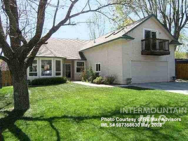 view of front of home featuring fence, a front yard, a balcony, a garage, and driveway