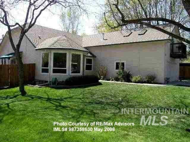 back of house with a yard and stucco siding