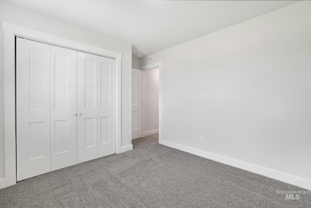unfurnished bedroom featuring carpet flooring, a closet, and baseboards