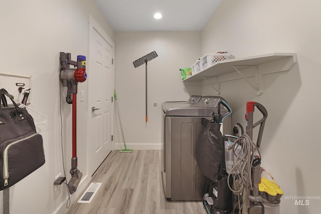 laundry area featuring washing machine and clothes dryer, light wood finished floors, baseboards, and recessed lighting