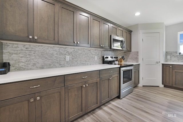 kitchen with appliances with stainless steel finishes, light countertops, light wood-style floors, backsplash, and recessed lighting