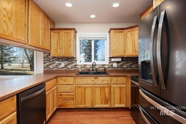 kitchen with range with electric stovetop, a sink, stainless steel refrigerator with ice dispenser, decorative backsplash, and dishwasher