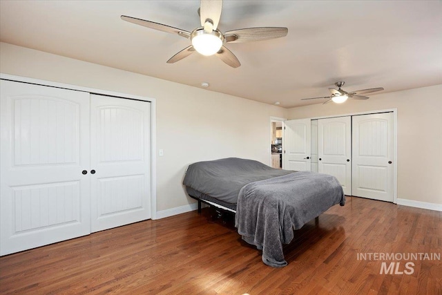 bedroom with multiple closets, ceiling fan, baseboards, and wood finished floors