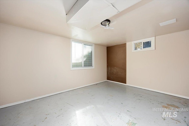 spare room with concrete floors and baseboards